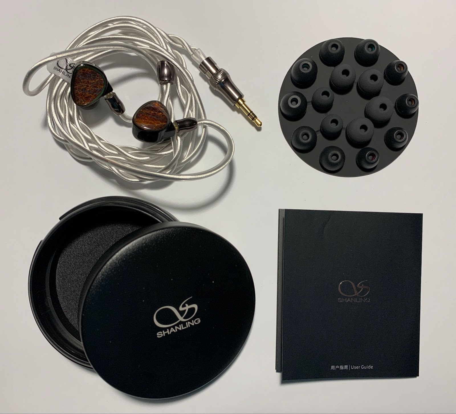 Inside, in the upper part, in a special foam base, the headphones are placed. Below, under the cardboard cover, there is a cable that is already connected to the headphones.