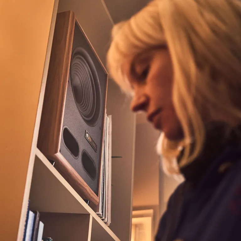 Vestlyd M8C Active Recasts the Power Monitor as a Complete Audio Hub 25 Woman standing beside an ungrilled Vestlyd speaker and records on a shelf